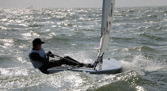 Laser ILCA 7 sailor hiking upwind in the Gulf
